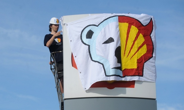 A Greenpeace activist covers the logo of the Shell oil company to protest against the heading of the an icebreaker for Shell's Arctic oil drilling project in the north of Alaska in 2012.
